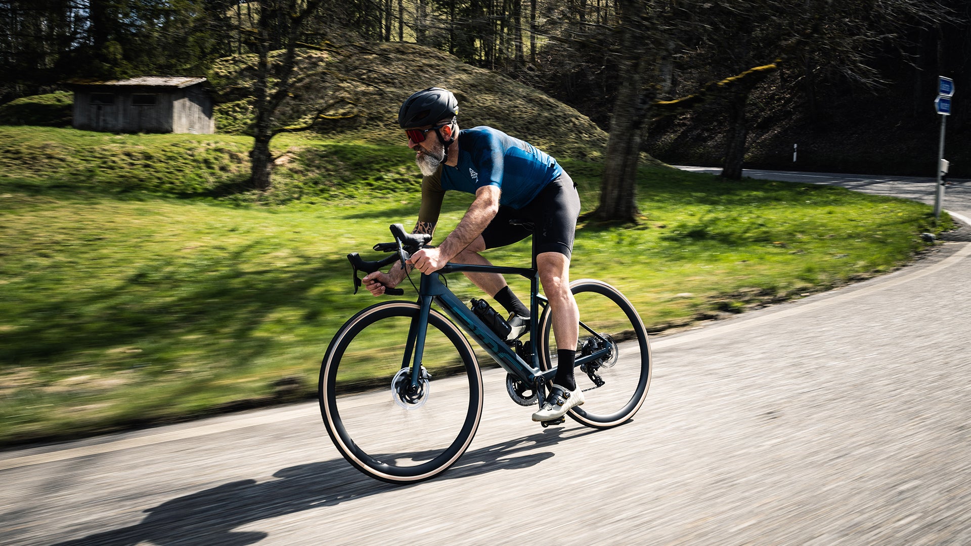 a man riding a BMC Roadmachine AMP electric Road bike up a hill