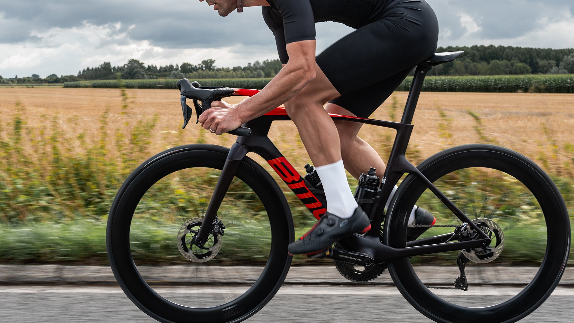 A man riding a BMC Teammachine R on a cobblestone road. 