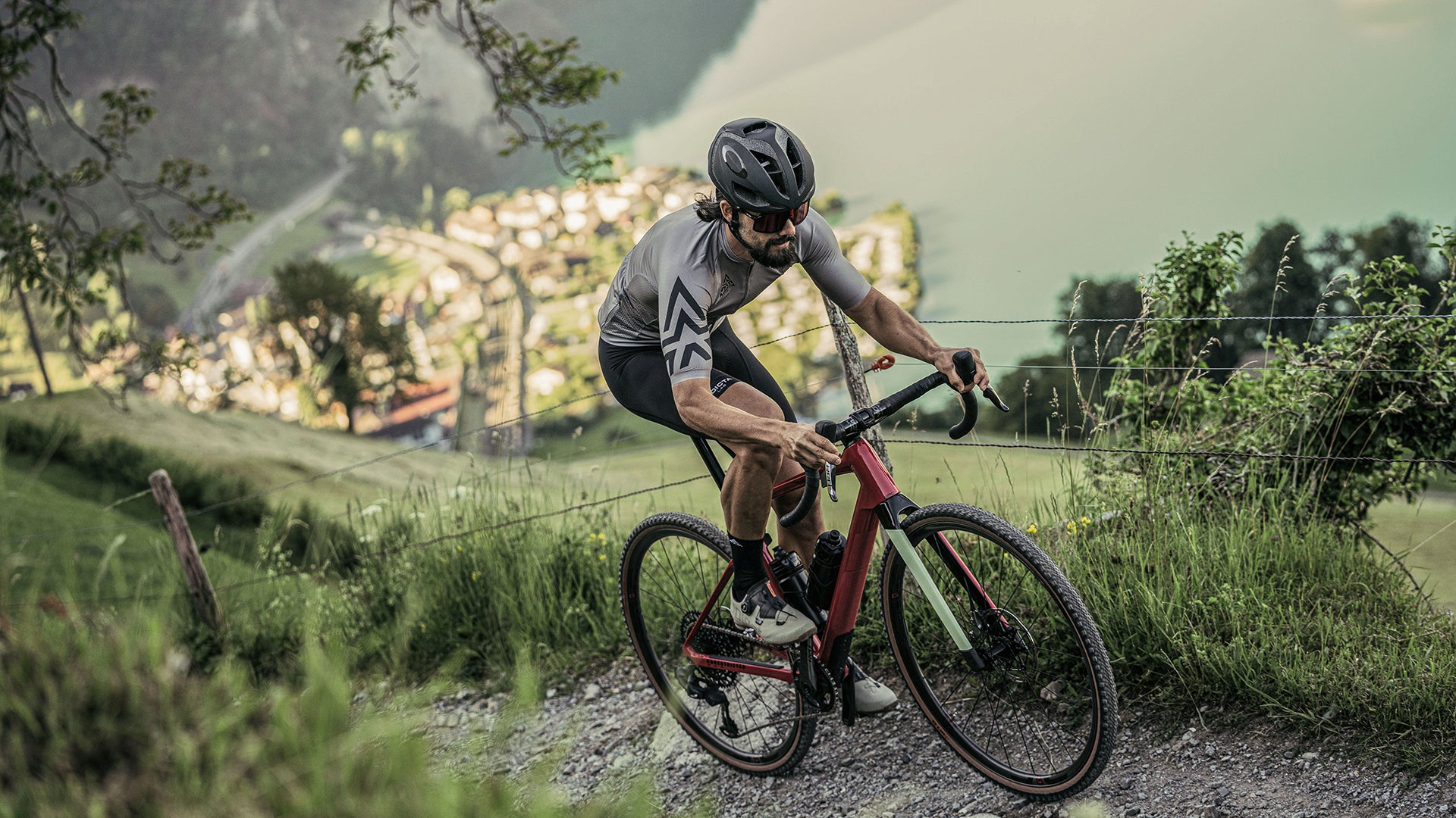 A man riding the BMC URS AMP electric gravel bike up a hill in the mountains. 