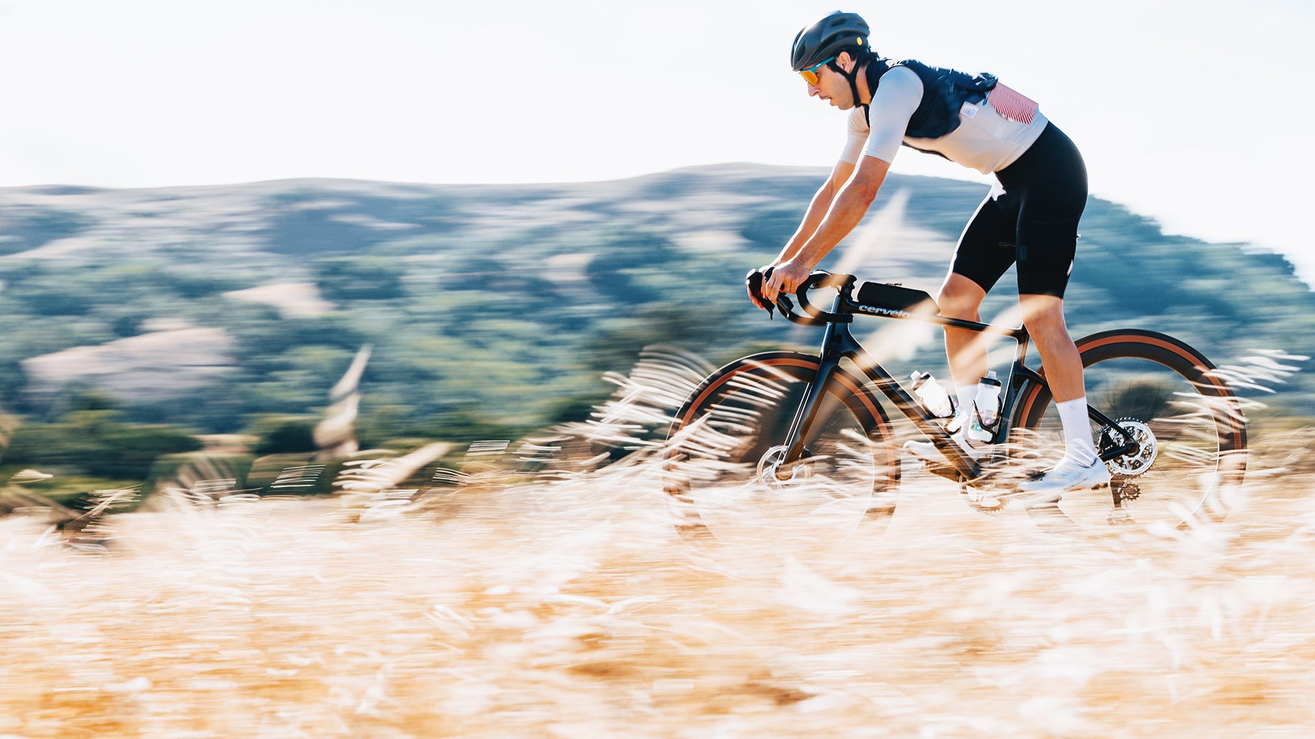A man riding a cervelo aspero gravel bike through high grass