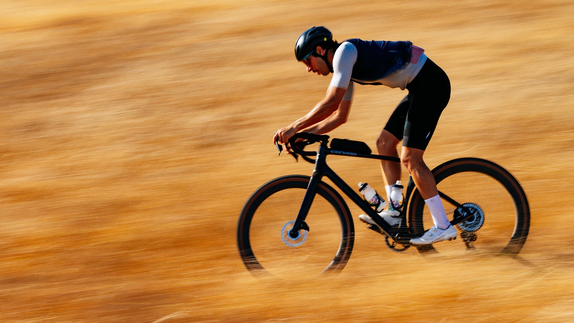 A man riding the cervelo aspero gravel bike against a brown hillside