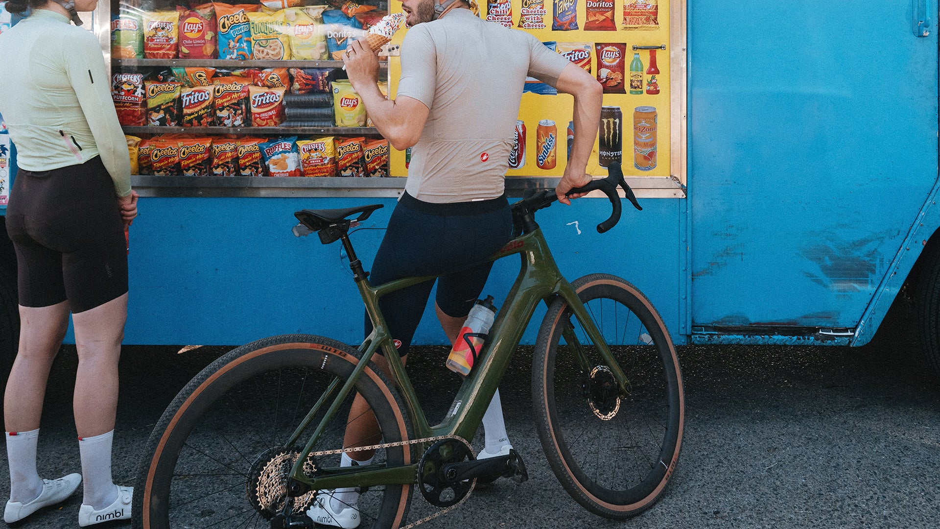A man sitting on a cervelo rouvida electric gravel bike against a food truck.