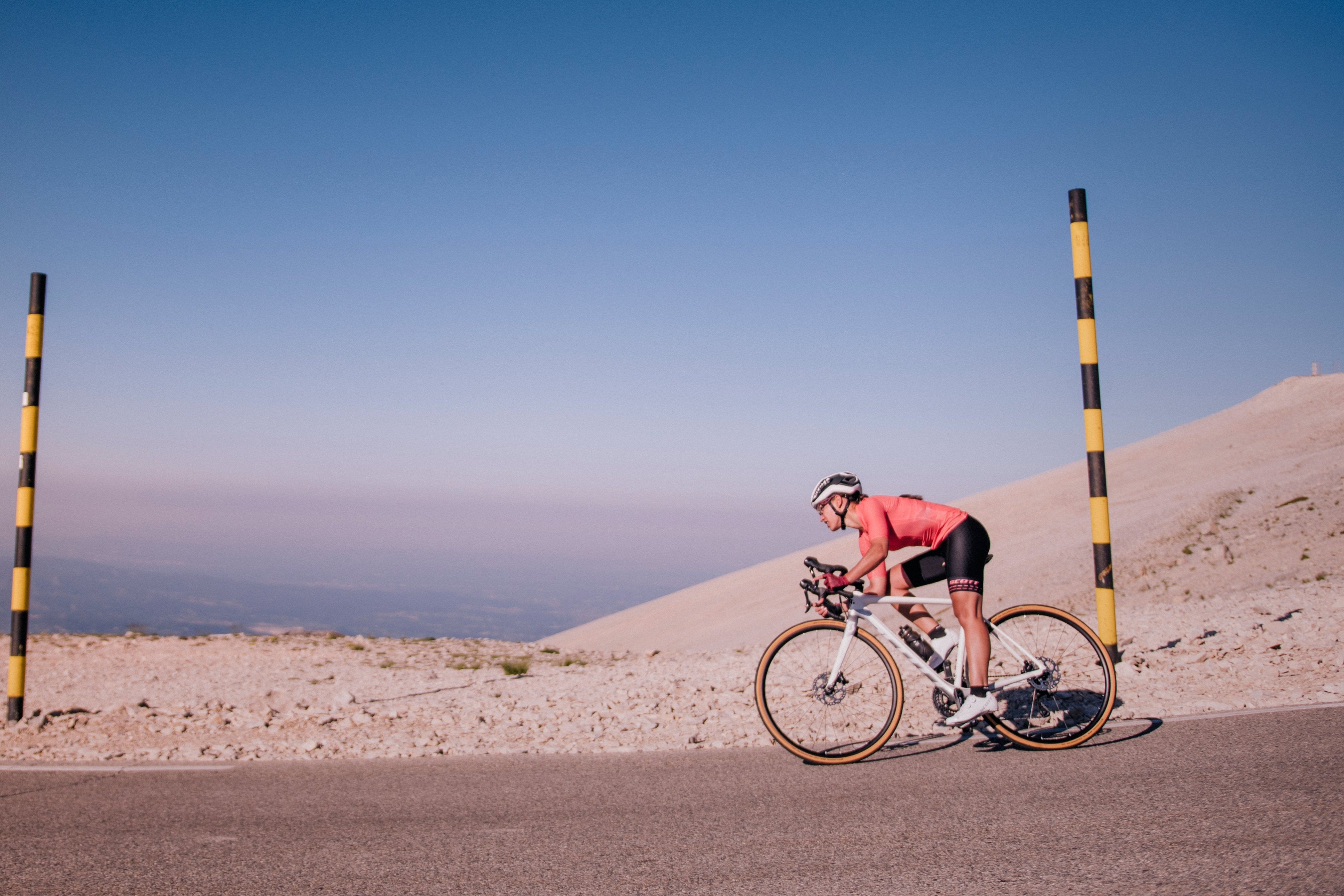 A woman riding a Scott Contessa road bike down a mountain.