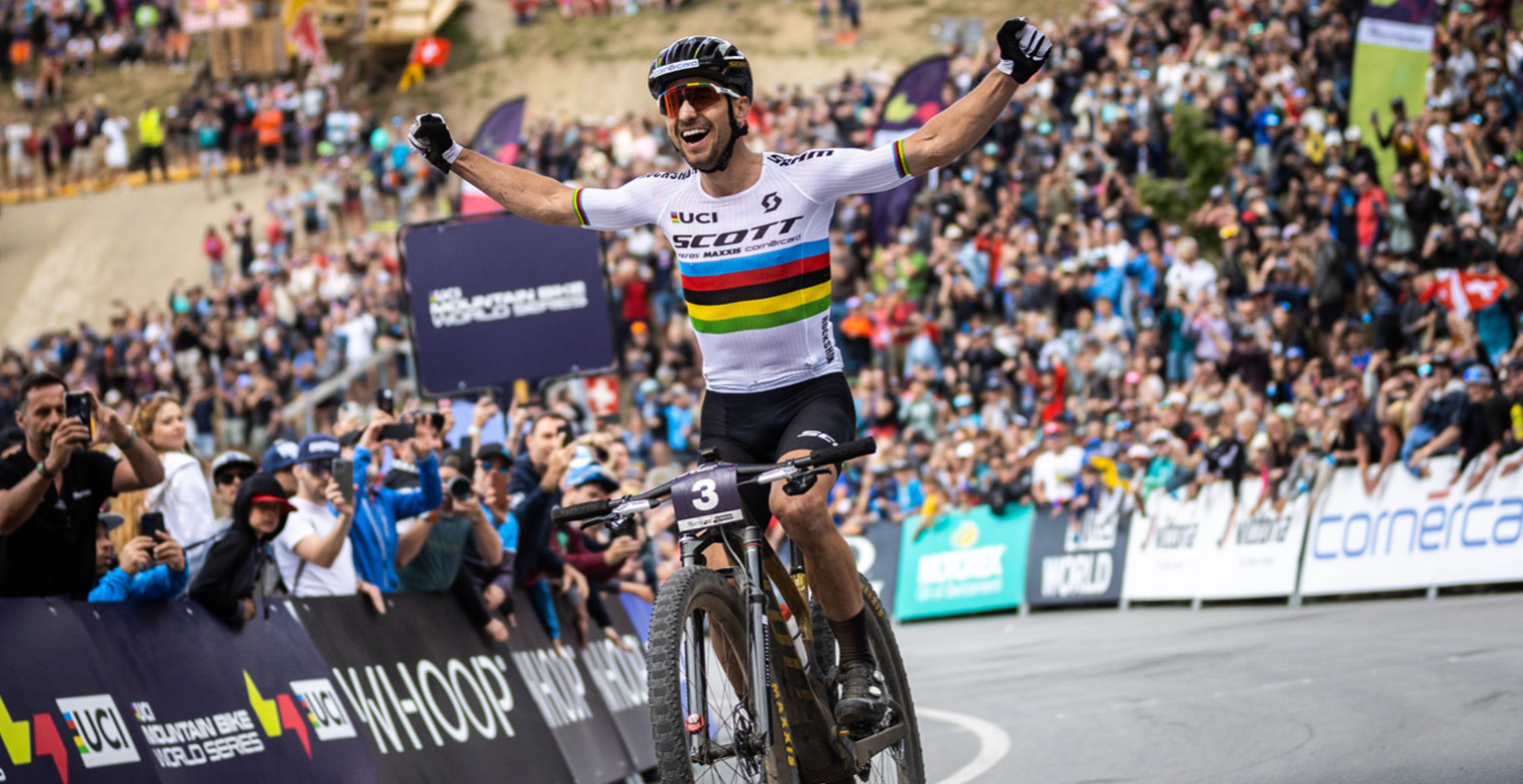 A man riding a Scott Spark RC mountain bike in the world mountain bike world championship.