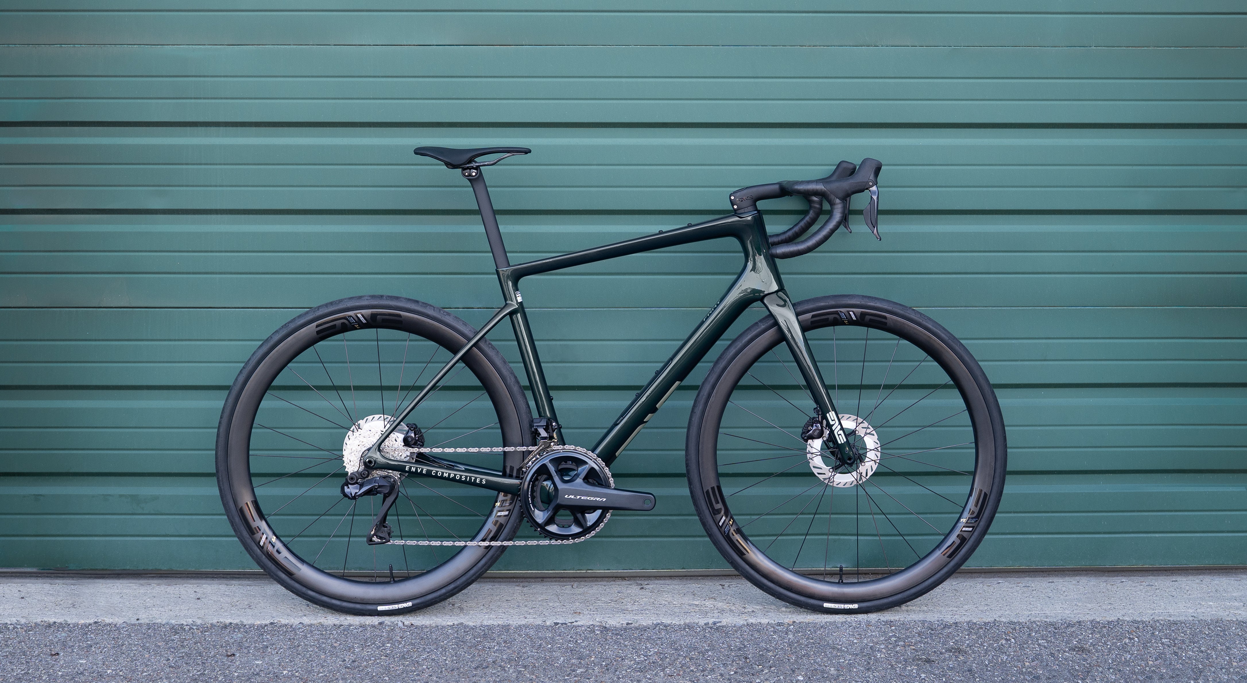 The Enve Fray gravel bike, in green, photographed against a green wall. 