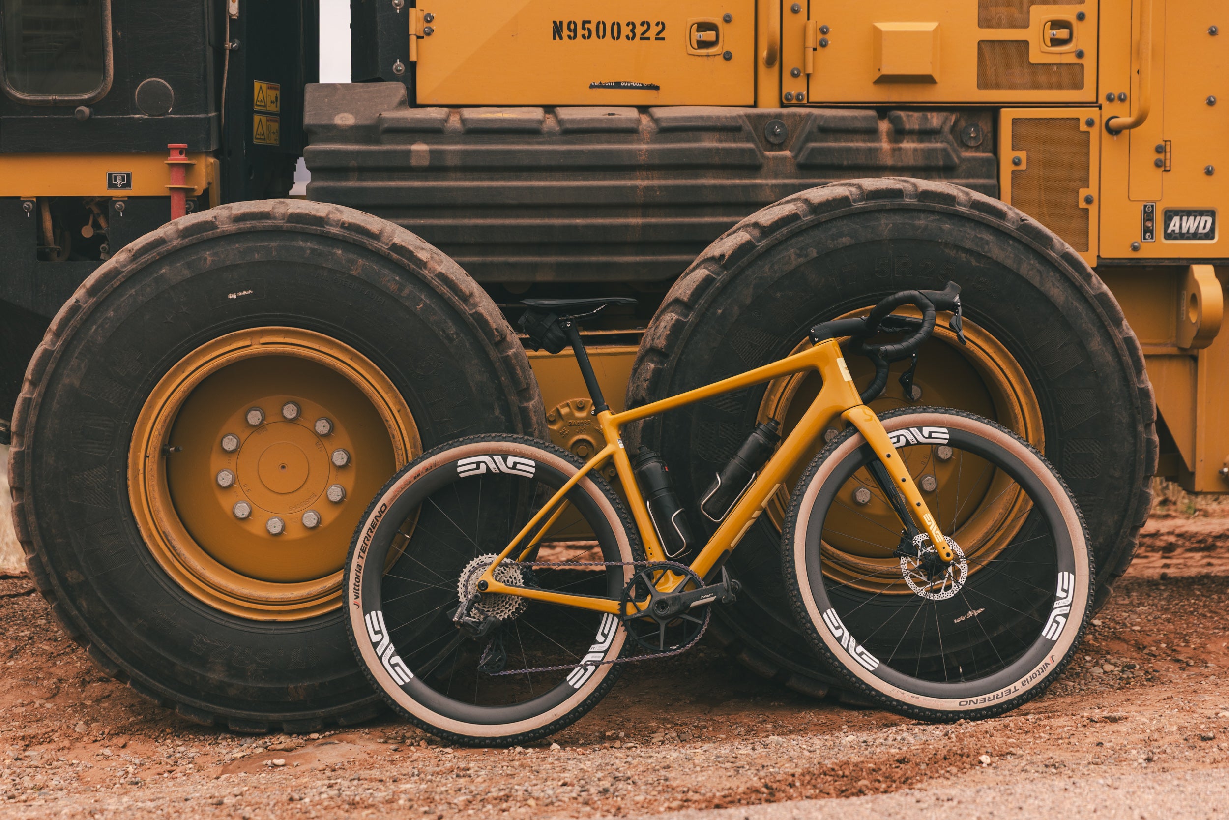 A yellow enve mog gravel bike against a yellow tractor