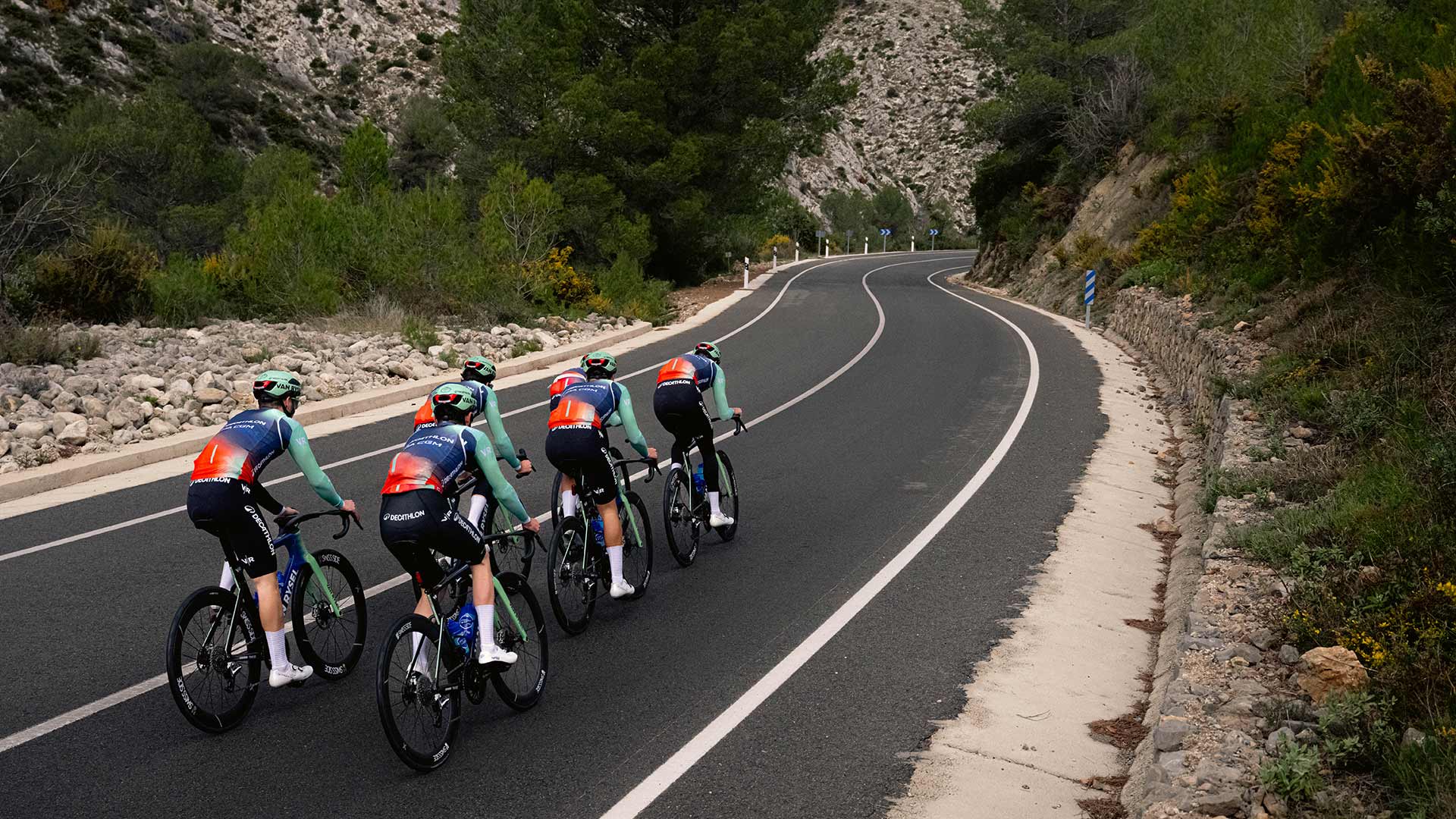 Cyclists in a line on a winding mountain road