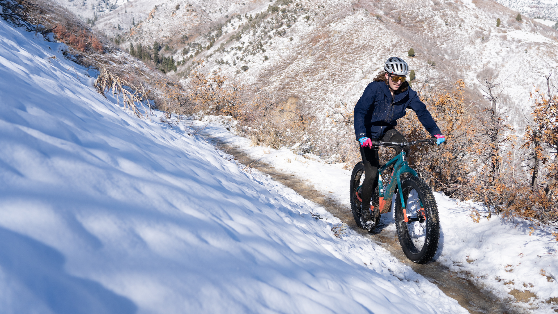 A man riding an Otso fat bike in the snowy mountains on a trail