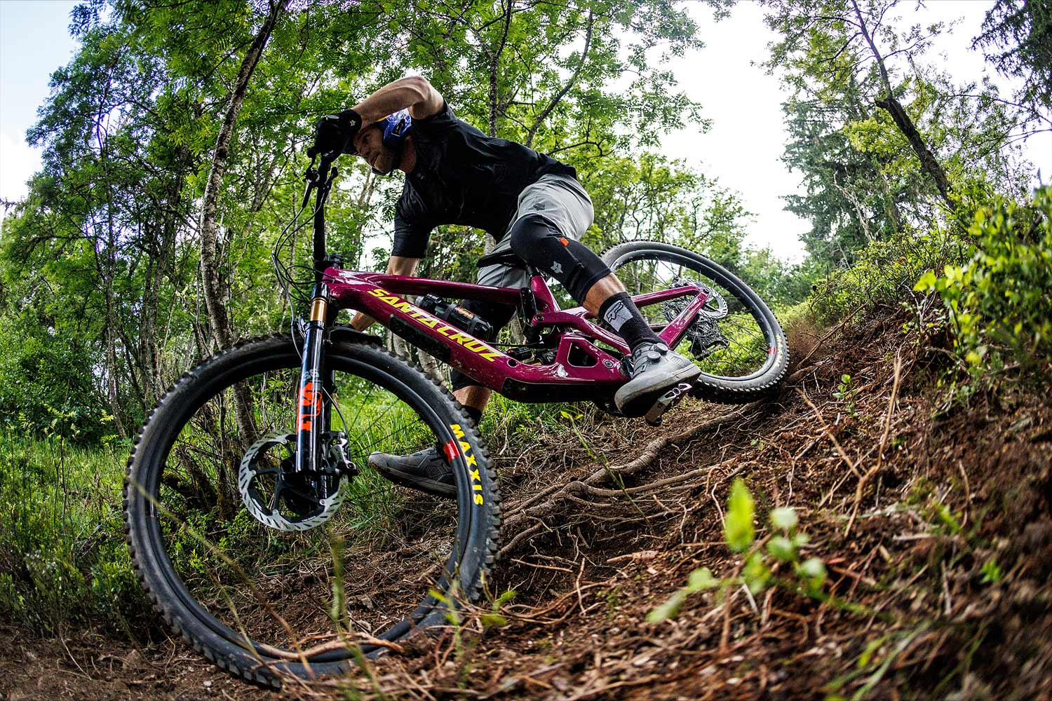 Cyclist riding a pink and yellow bike down a trail.
