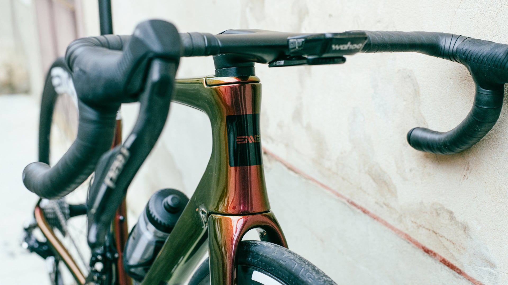 an orange colored enve melee road bike against a wall.