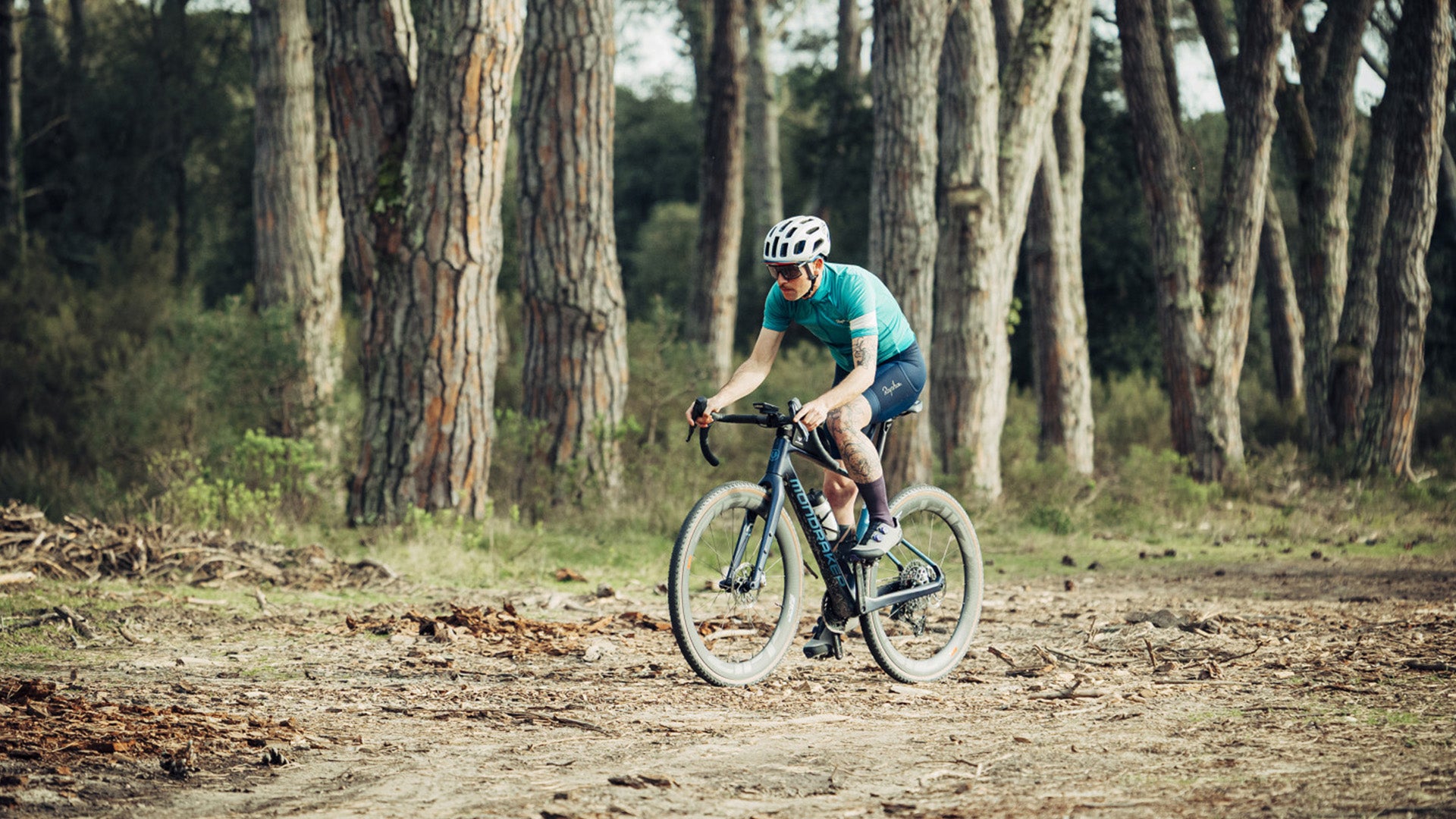 a person riding mondraker gravel bike in a forest