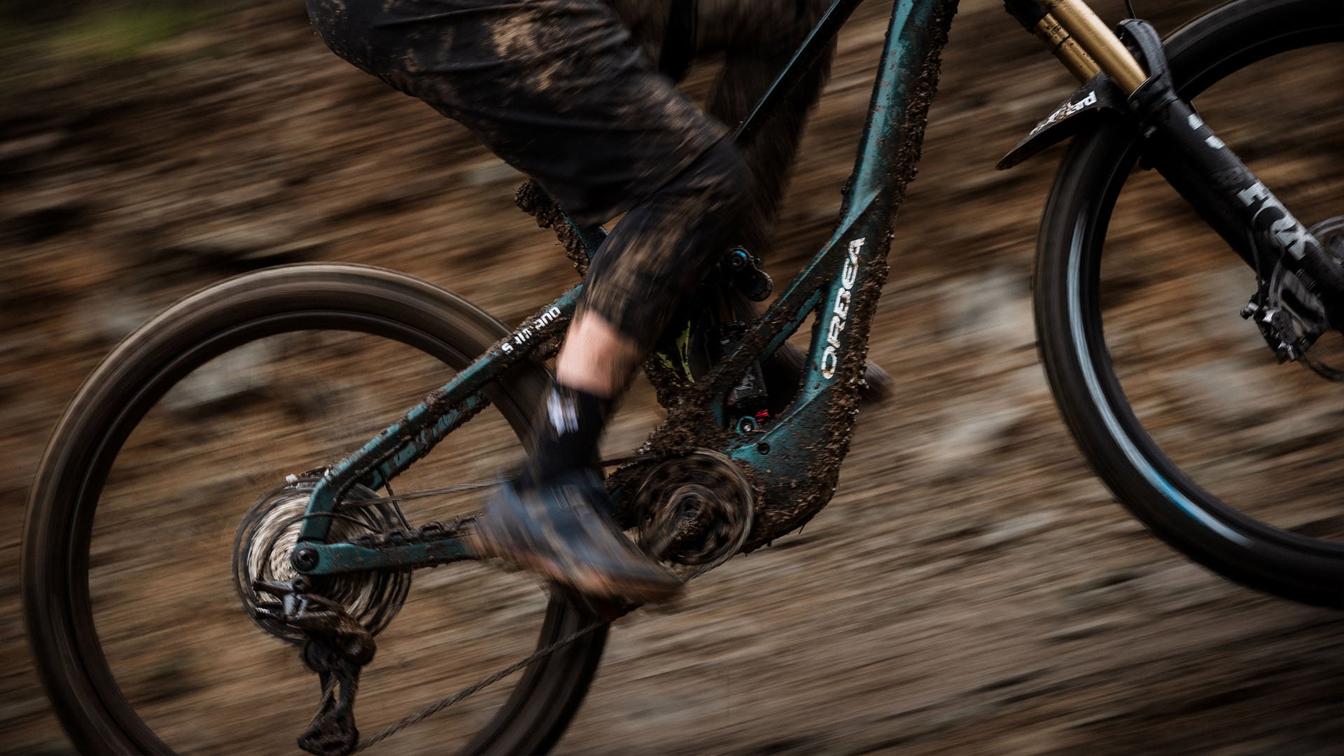Green Orbea Wild LT ridden through mud.