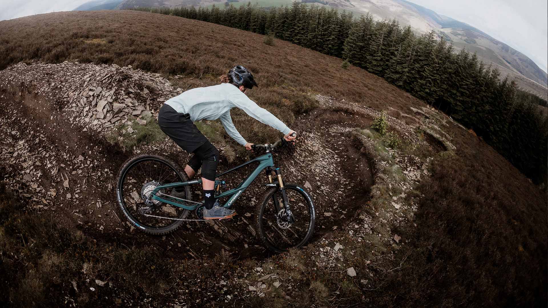 Green Orbea Wild LT being ridden through a berm.