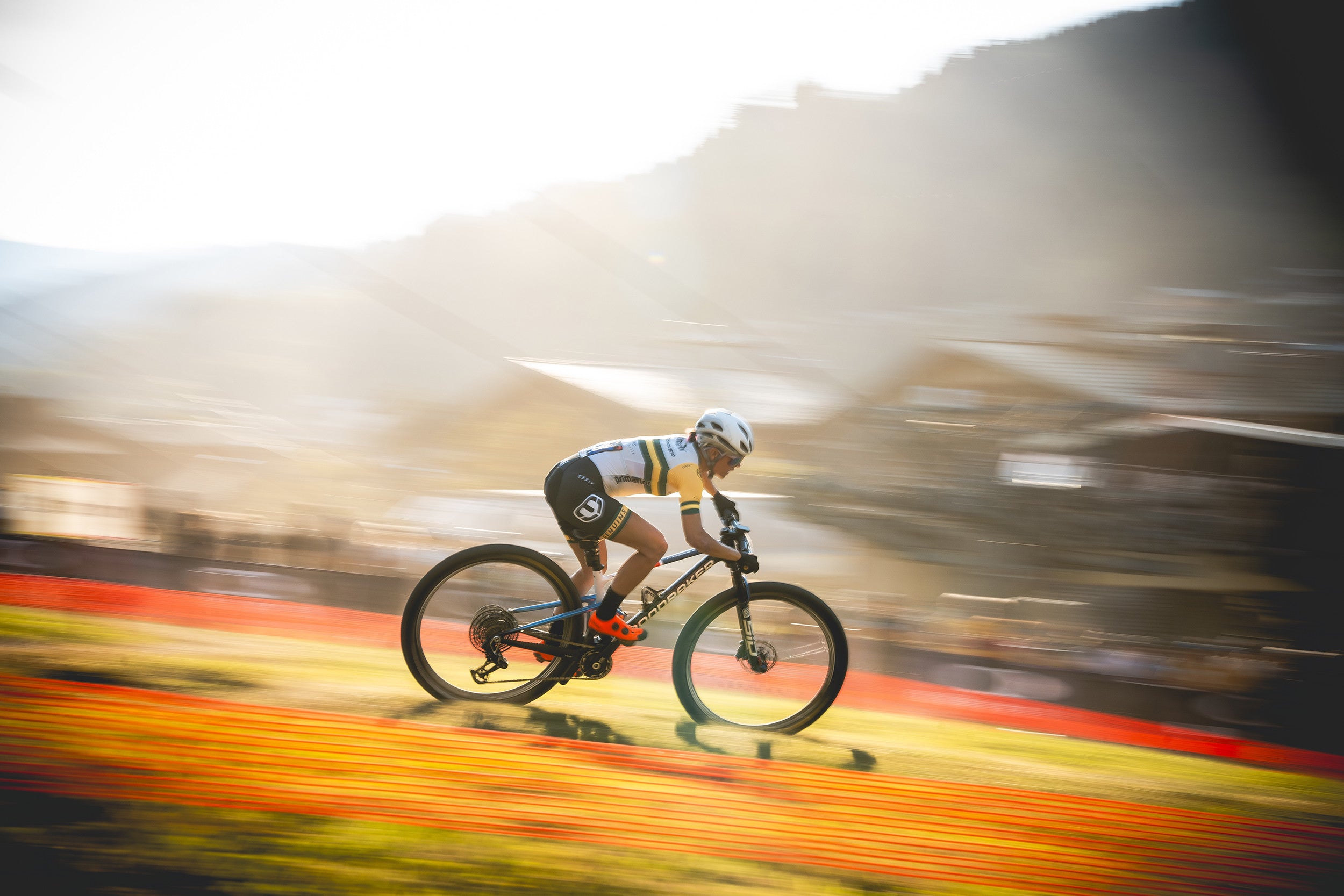 A woman riding a Mondraker F Podium Cross Country Bike, available at Contender Bicycles. 