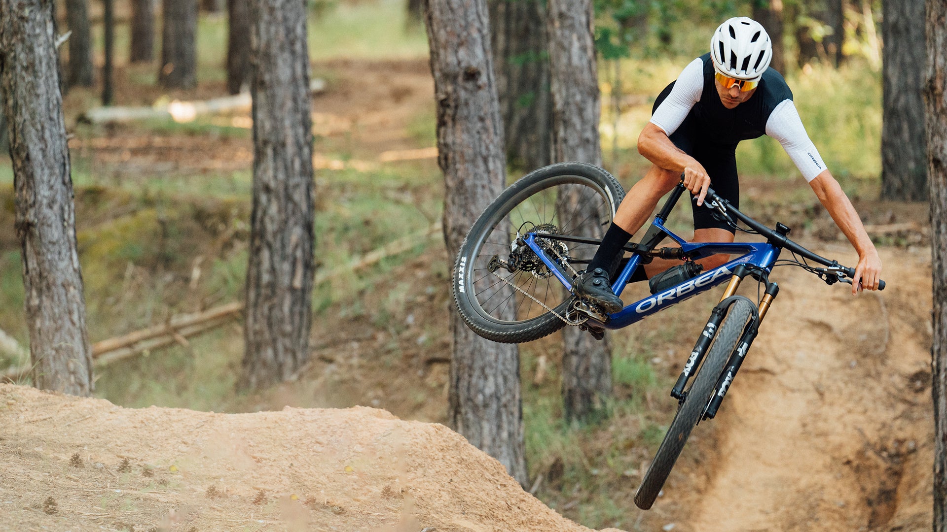 A man riding the orbea Oiz Cross country bike over a Jump