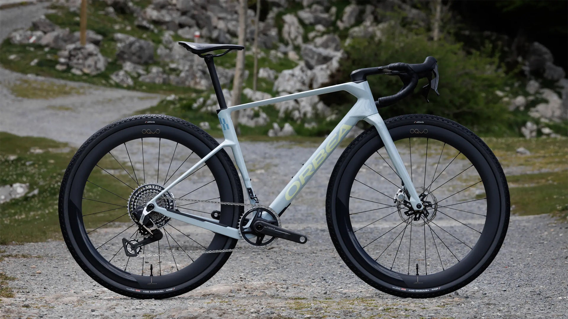 a Blue Orbea terra race against a mountainous backdrop. 