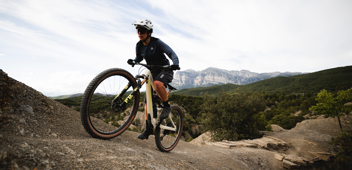A woman riding a bike up a mountain side