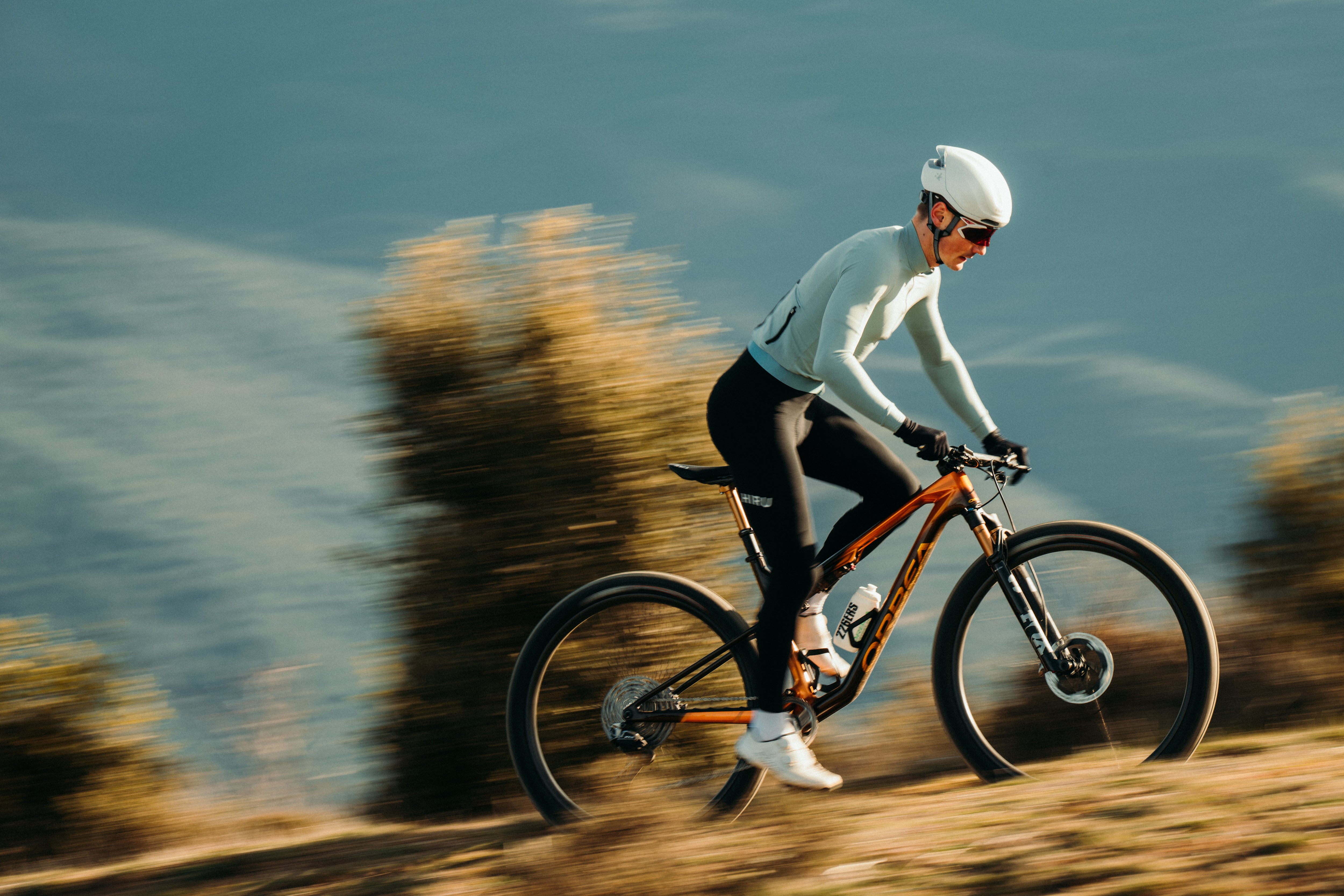 Person riding a mountain bike on a trail with a scenic background