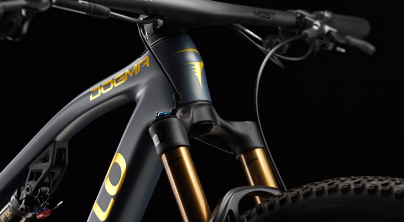 The pinarello dogma XC in black and gold against a black background. 
