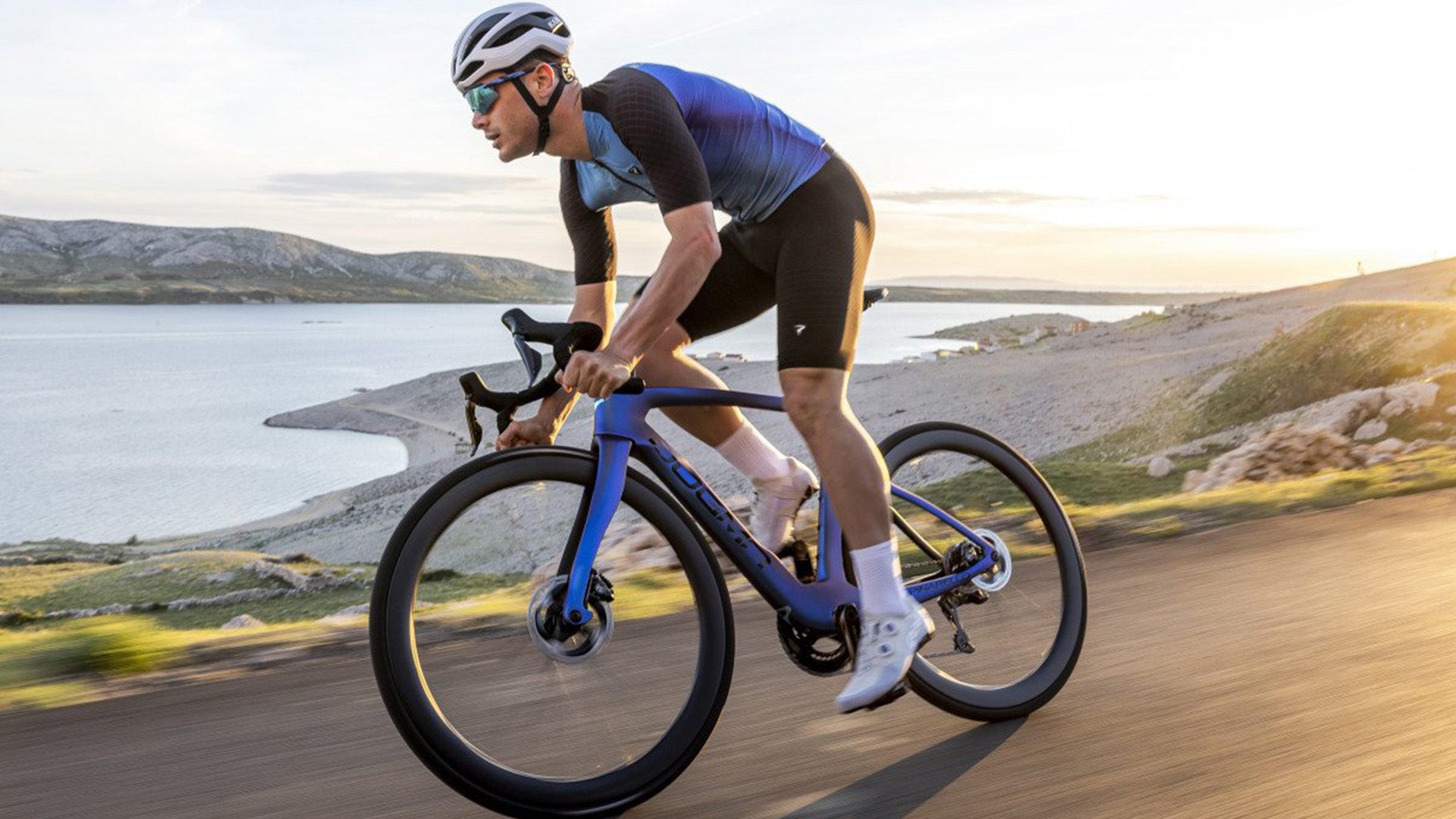 A Man riding the Pinarello Dogma F Road bike against some mountains
