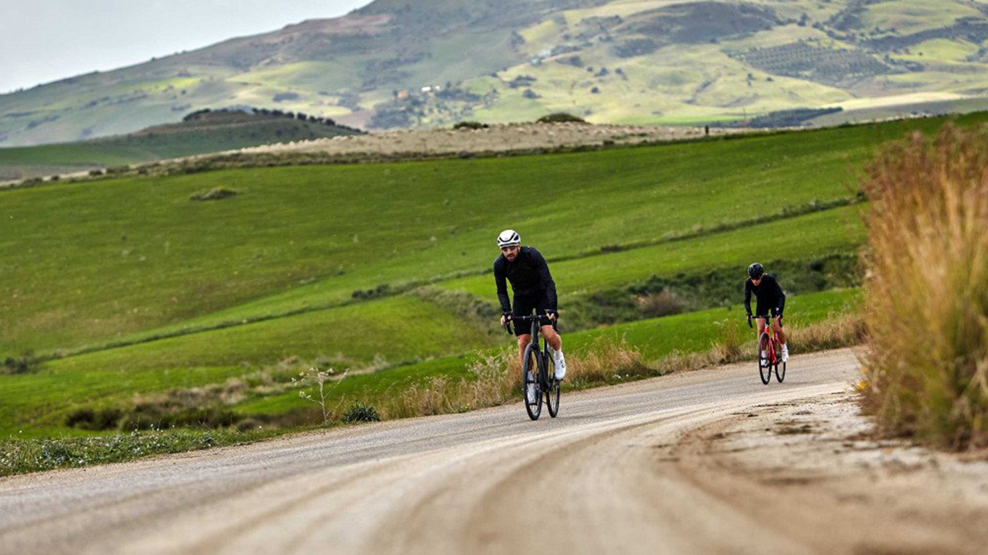 A Man riding the Pinarello X Road bike against a vineyard