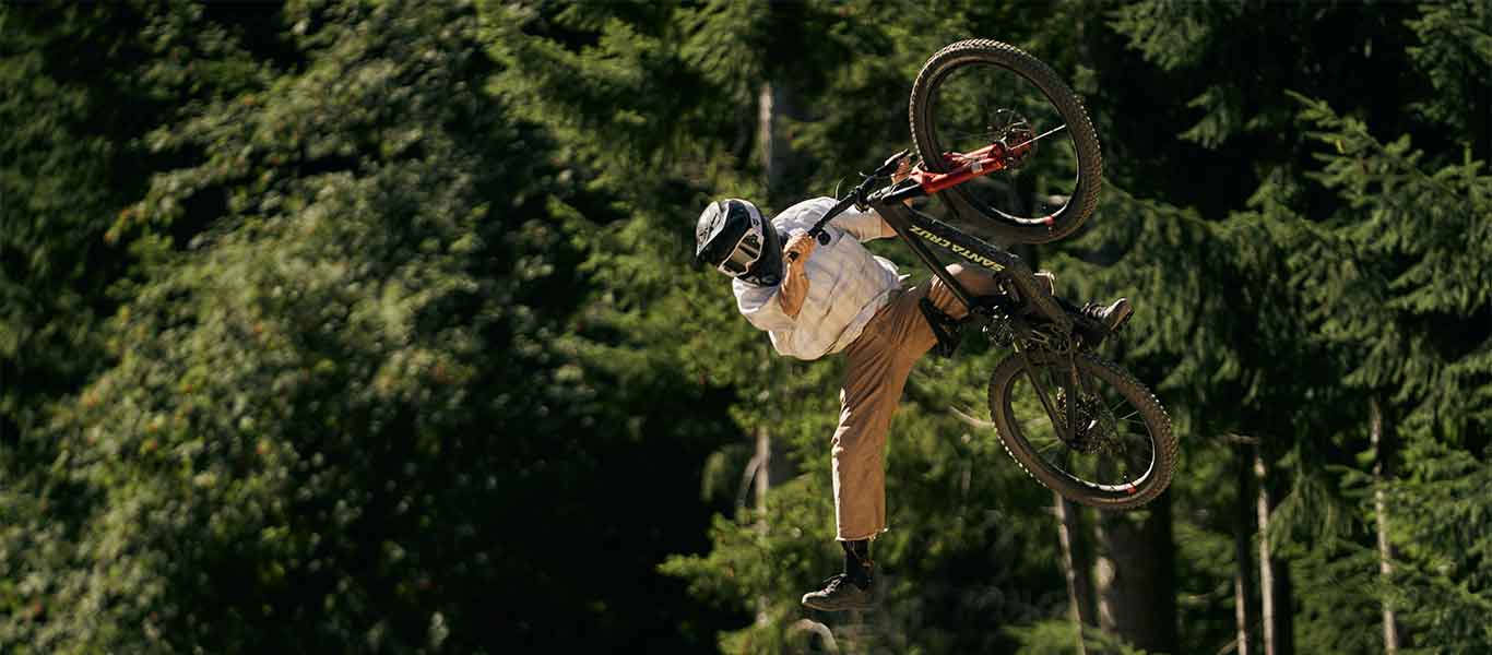 Person on a bicycle performing a trick with trees in the background