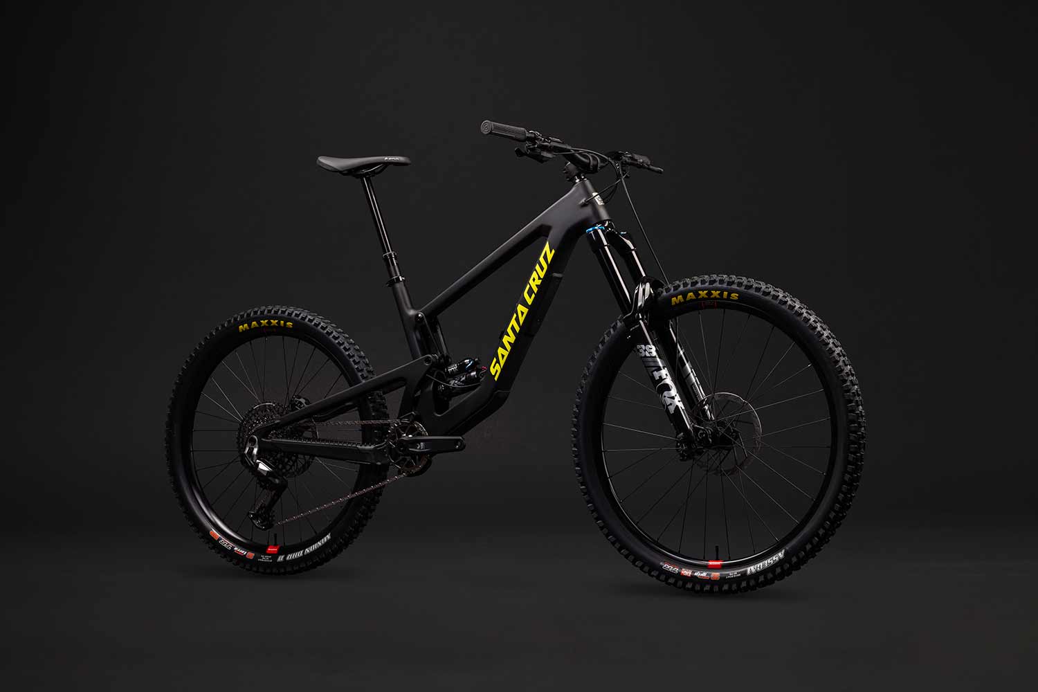 Black and yellow Santa Cruz Nomad in front of grey background.