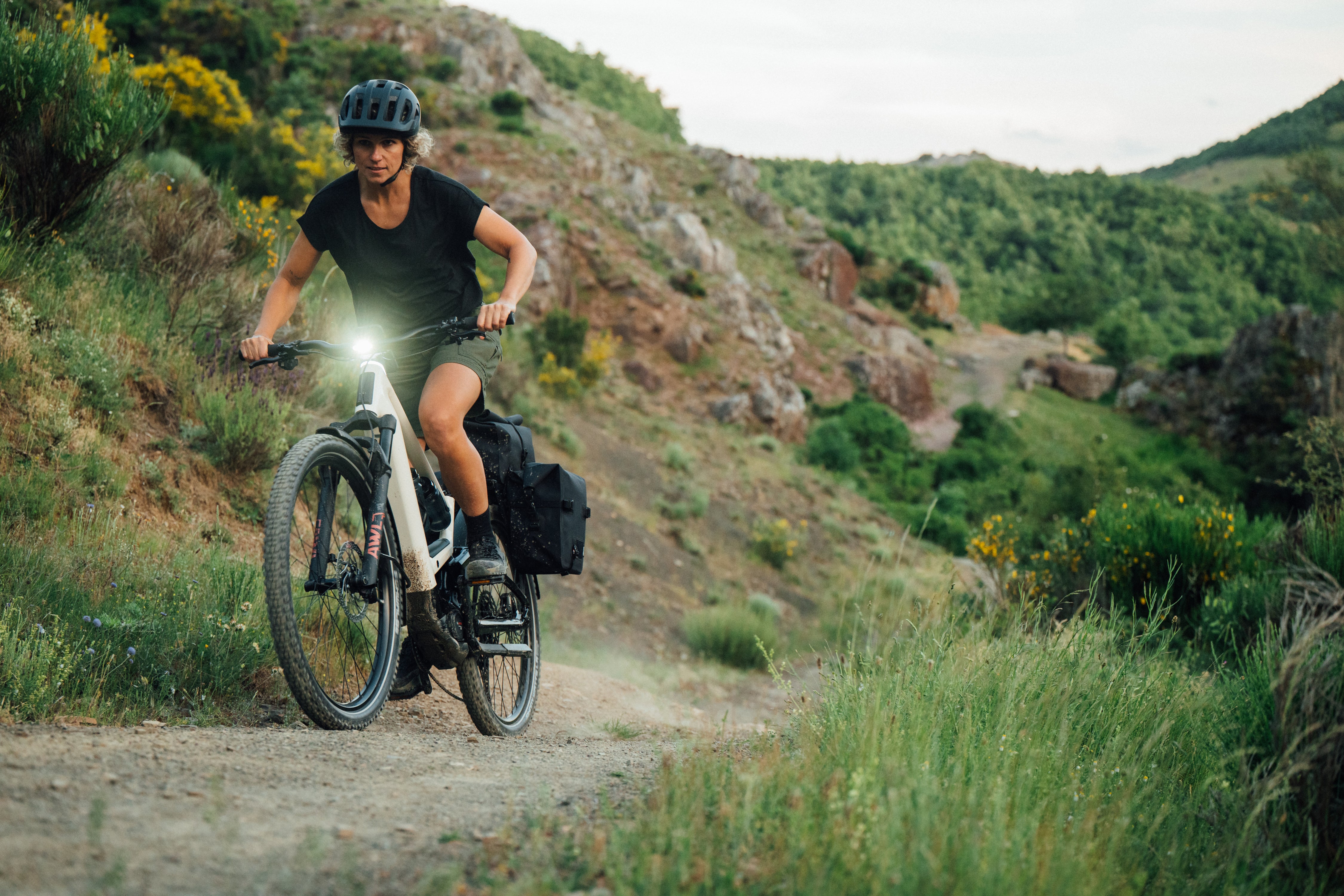 The Orbea Muga electric bike being ridden on a trail by a woman. 
