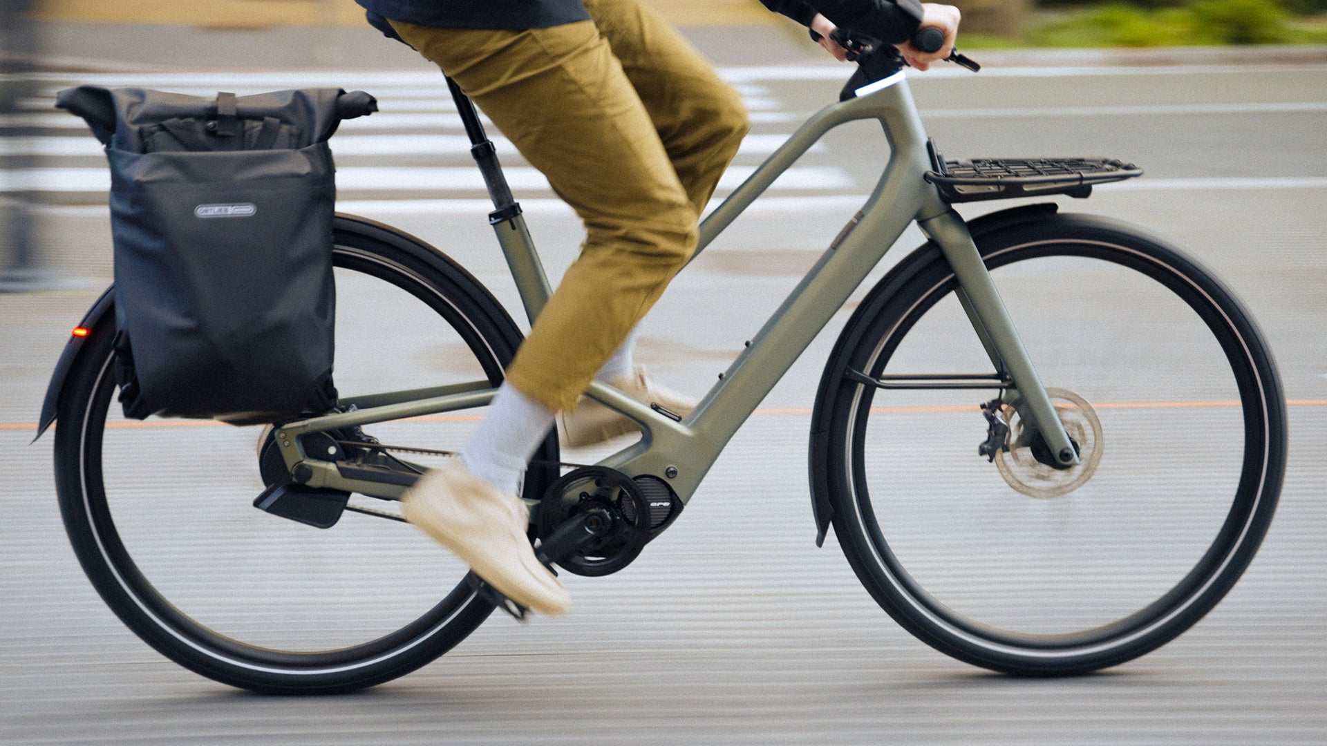 a man riding an Orbea Diem electric bike in a city.