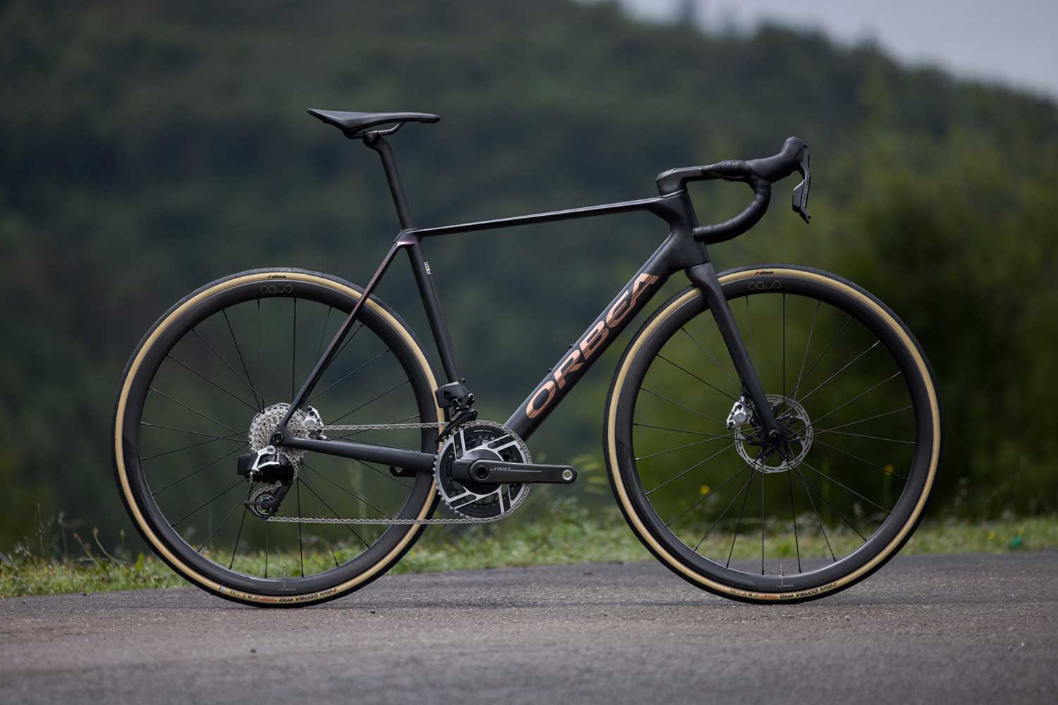 Orbea bicycle on a road with a blurred natural background.